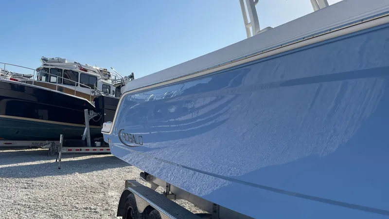 Slide: The Image of 2023 Robalo R272 Center Console boat in a marina, side view. - 8