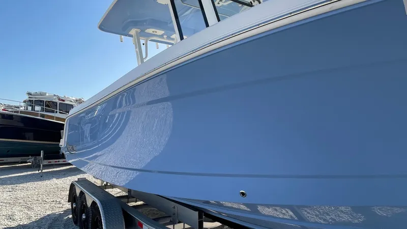 Slide: The Image of 2023 Robalo R272 Center Console boat on trailer, side view, blue hull. - 9