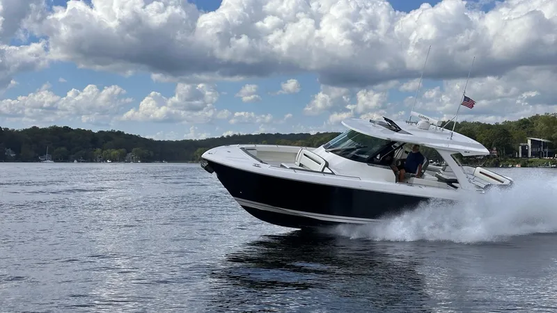 Slide: The Image of 2021 Tiara Yachts 38 LS cruising on a lake under a partly cloudy sky. - 7