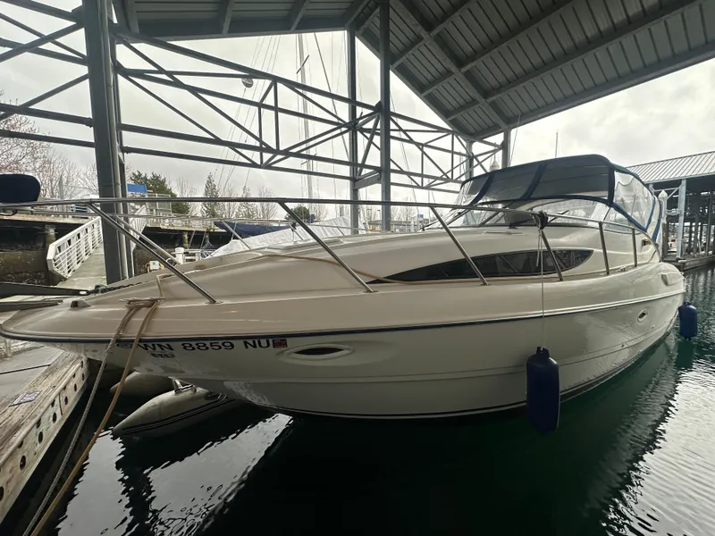 The Image of 2005 Bayliner 305 boat docked in a covered marina, side view. - 0