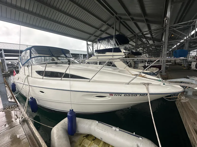 Slide: The Image of 2005 Bayliner 305 boat docked under a covered marina. - 1