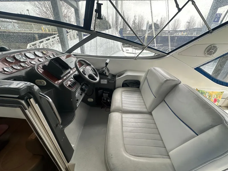 Slide: The Image of 2005 Bayliner 305 boat interior with steering wheel, dashboard, and gray seating. - 11