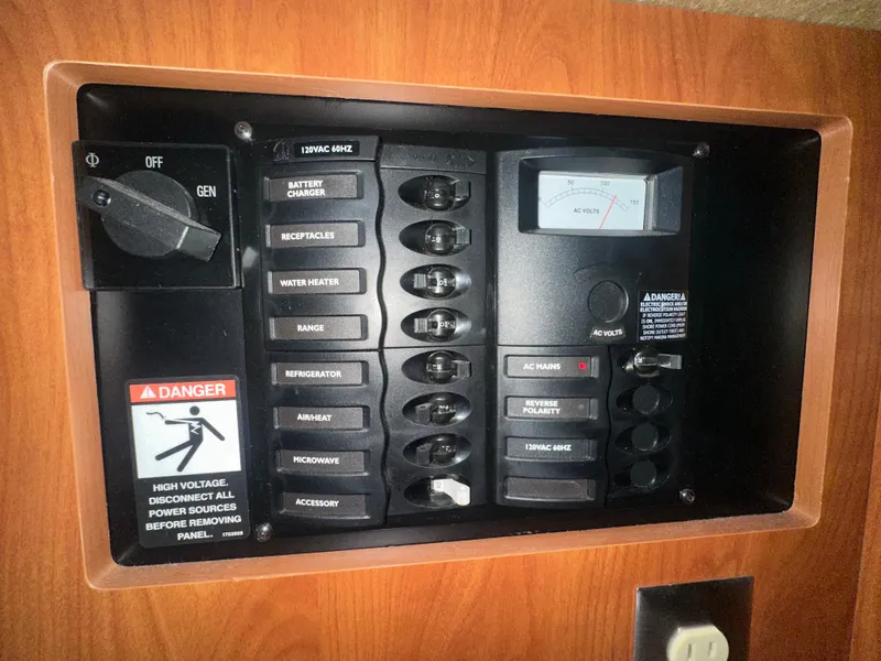 Slide: The Image of Electrical control panel on a 2005 Bayliner 305 boat, featuring various switches and a voltage meter. - 20