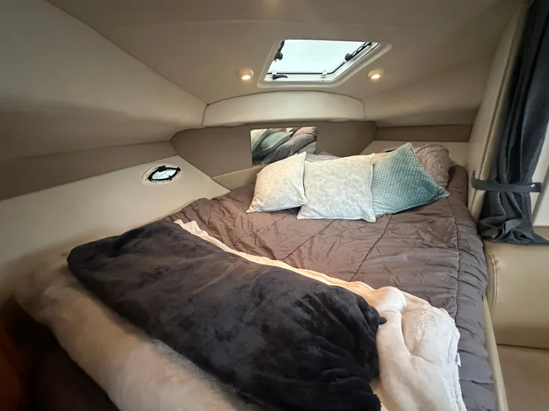 Slide: The Image of Cozy cabin interior of 2005 Bayliner 305 with plush bedding and soft lighting. - 27