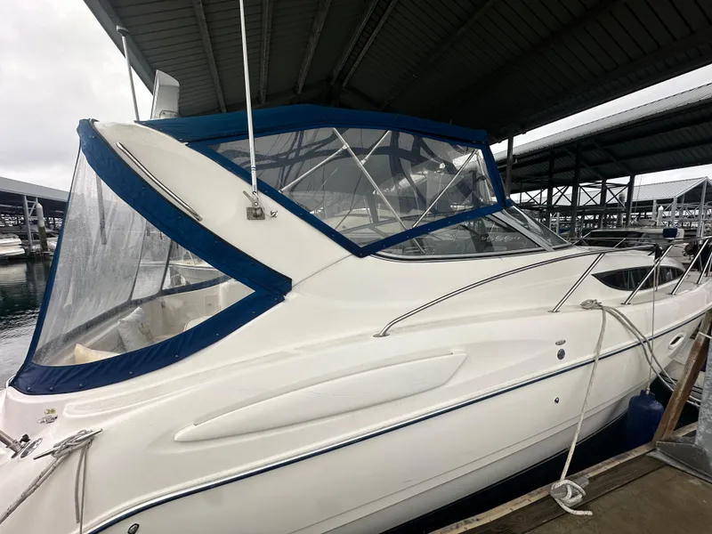Slide: The Image of 2005 Bayliner 305 boat docked under a covered marina. - 3