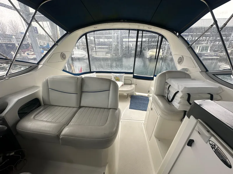 Slide: The Image of Interior view of 2005 Bayliner 305 boat with seating and marina backdrop. - 31