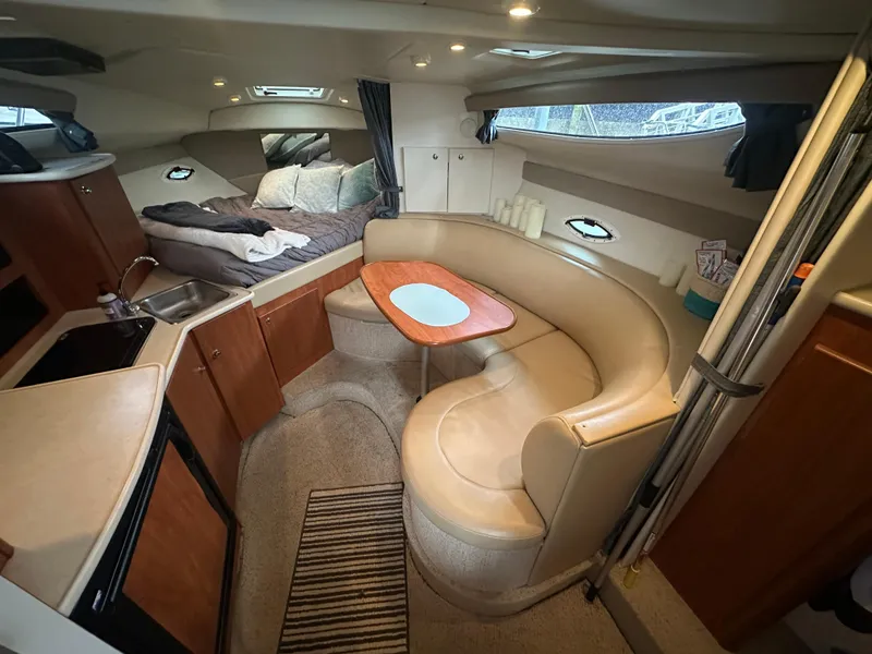 Slide: The Image of 2005 Bayliner 305 interior with cozy seating, kitchenette, and sleeping area. - 33