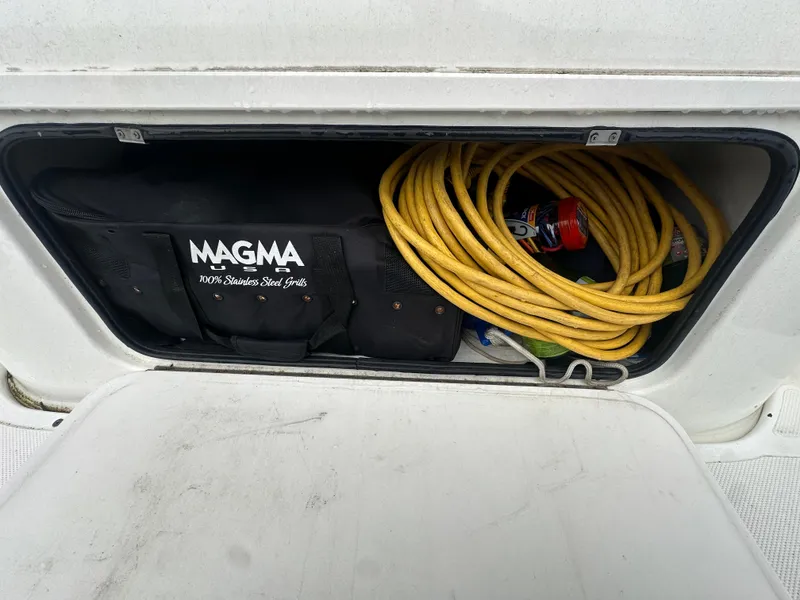 Slide: The Image of Storage compartment on a 2005 Bayliner 305 with Magma grill bag and yellow hose. - 5