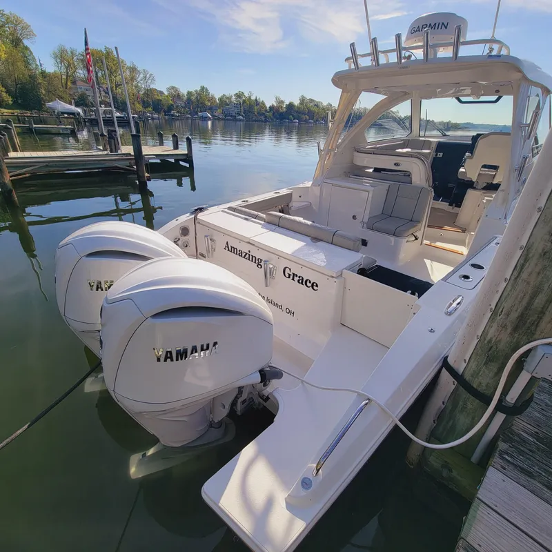 Slide: The Image of 2023 Pursuit OS 325 Offshore boat docked with twin Yamaha engines. - 15