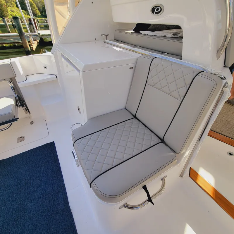 Slide: The Image of 2023 Pursuit OS 325 Offshore boat interior with cushioned seating and storage. - 18