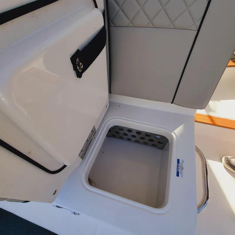 Slide: The Image of 2023 Pursuit OS 325 Offshore boat storage compartment with open hatch. - 21