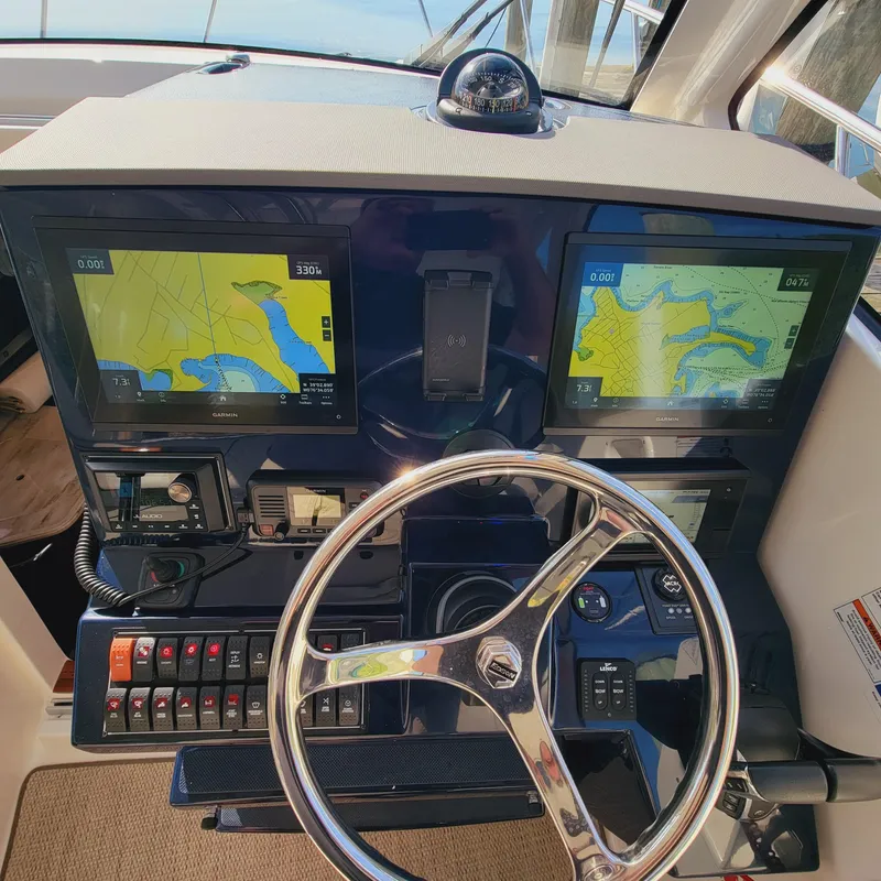 Slide: The Image of 2023 Pursuit OS 325 Offshore helm with dual navigation screens and steering wheel. - 26