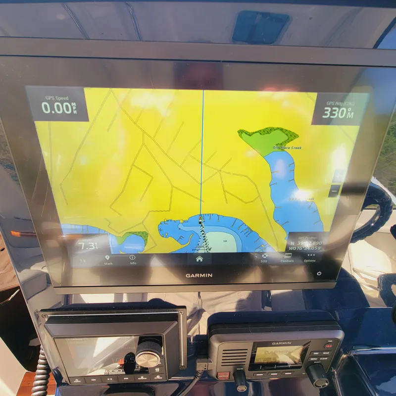 Slide: The Image of Garmin navigation display on 2023 Pursuit OS 325 Offshore boat, showing map and controls. - 28