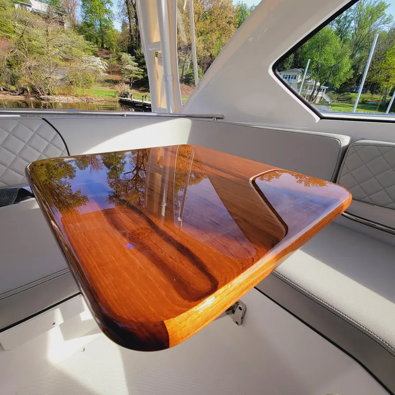 Slide: The Image of Luxurious interior of 2023 Pursuit OS 325 Offshore with polished wooden table and cushioned seating. - 31