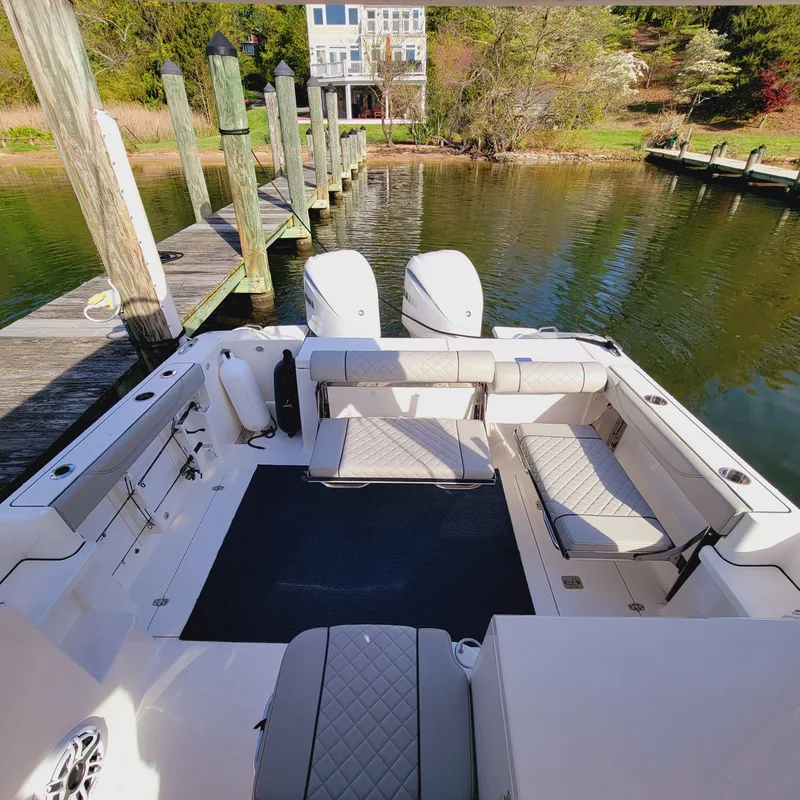 Slide: The Image of 2023 Pursuit OS 325 Offshore boat docked, featuring spacious seating and dual engines. - 38