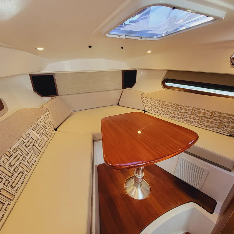 Slide: The Image of 2023 Pursuit OS 325 Offshore cabin interior with elegant seating and wooden table. - 40