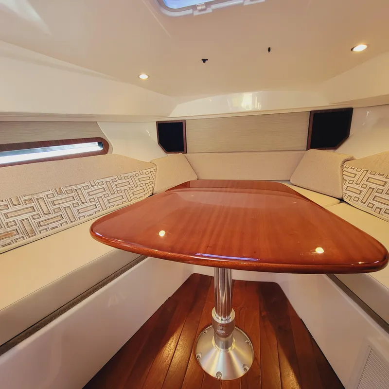 Slide: The Image of 2023 Pursuit OS 325 Offshore cabin with elegant wooden table and cushioned seating. - 41