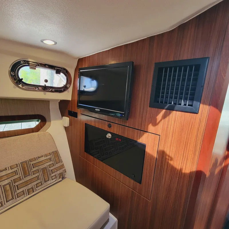 Slide: The Image of 2023 Pursuit OS 325 Offshore cabin interior with TV and seating. - 43