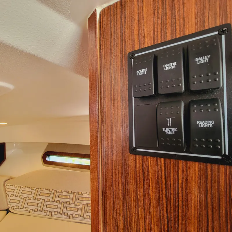 Slide: The Image of Control panel on 2023 Pursuit OS 325 Offshore boat, featuring various light switches. - 44
