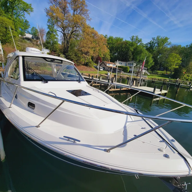 Slide: The Image of 2023 Pursuit OS 325 Offshore boat docked in a scenic marina setting. - 8