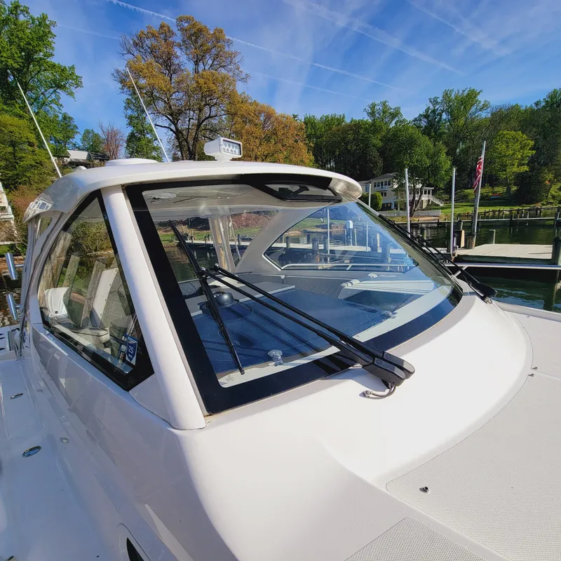 Slide: The Image of 2023 Pursuit OS 325 Offshore boat docked, showcasing sleek design and windshield wipers. - 9