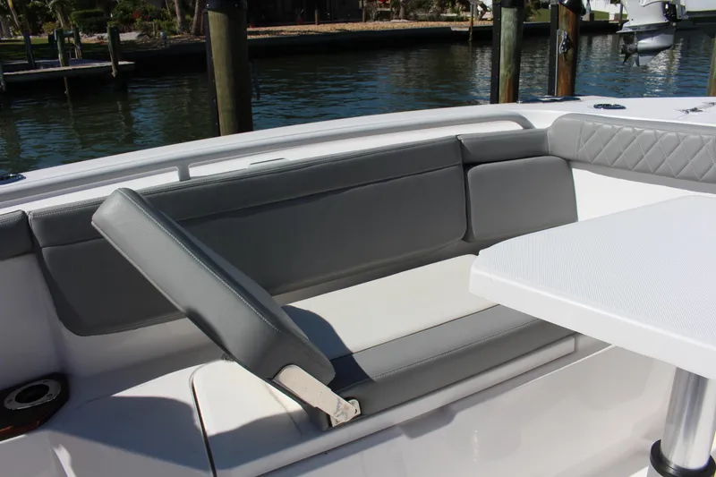 Slide: The Image of 2024 Everglades 395 Center Console boat interior with seating and table on calm water. - 15