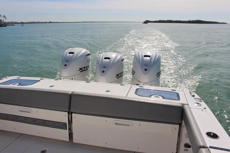 Slide: The Image of 2024 Everglades 395 Center Console boat with triple outboard engines and seating. - 29