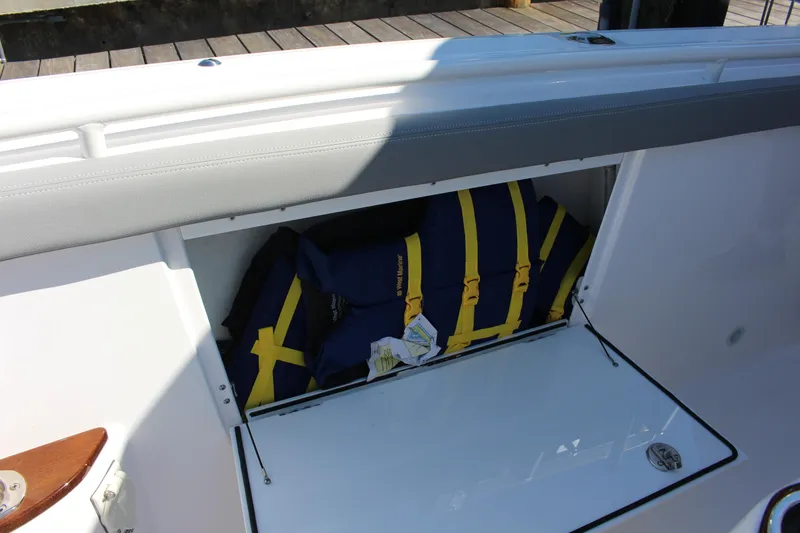 Slide: The Image of 2024 Everglades 395 Center Console boat with canopy, docked by a scenic waterfront. - 40