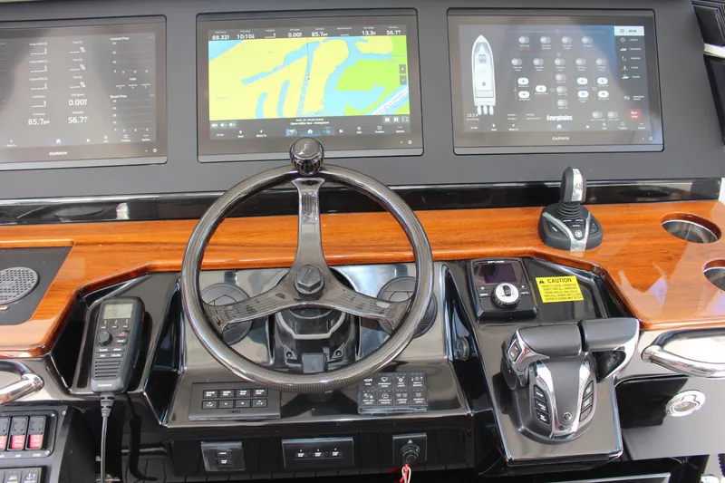 Slide: The Image of 2024 Everglades 395 Center Console helm with steering wheel and navigation displays. - 5