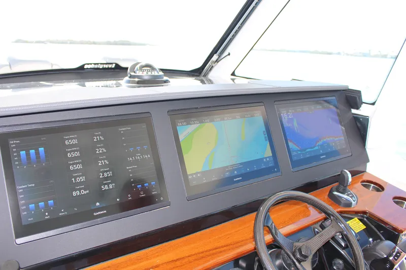 Slide: The Image of 2024 Everglades 395 Center Console boat with Garmin equipment, docked near palm trees. - 7