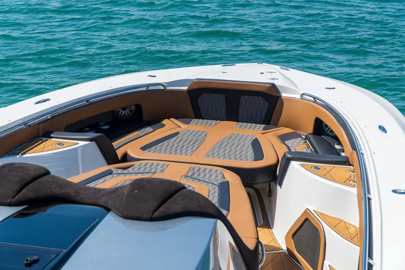 Slide: The Image of Luxury MTI V50 boat interior with cushioned seating, 2022 model, on clear blue water. - 10