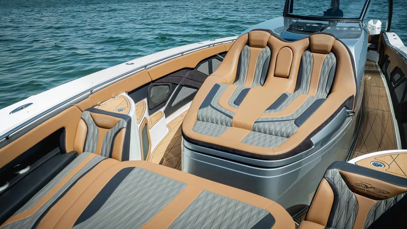 Slide: The Image of Luxurious 2022 MTI V50 boat interior with tan and gray seating on water. - 17