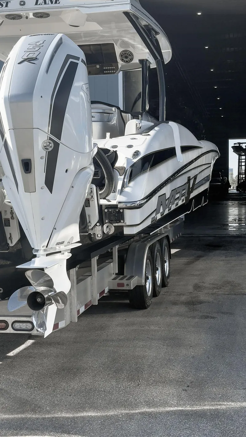 Slide: The Image of 2022 MTI V50 boat on trailer in a dimly lit garage. - 35