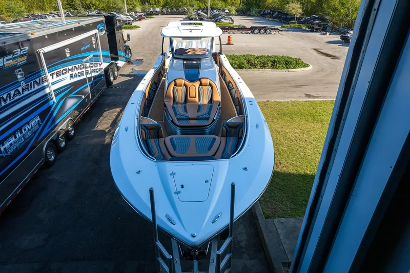 Slide: The Image of 2022 MTI V50 boat with sleek design and luxurious seating, parked outdoors. - 44