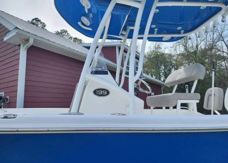 Slide: The Image of 2022 Sea Pro 199 Deep V Center Console boat with blue hull near red building. - 4
