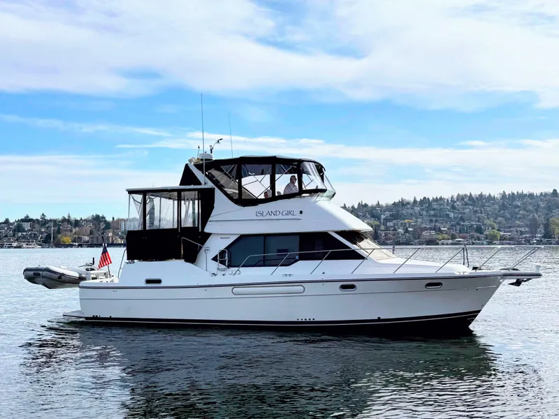 Slide: The Image of 2002 Bayliner 4087 Aft Cabin Motoryacht on calm water with scenic background. - 0