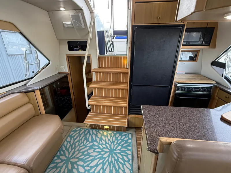 Slide: The Image of Interior of 2002 Bayliner 4087 Aft Cabin Motoryacht with stairs, seating, and kitchen area. - 13