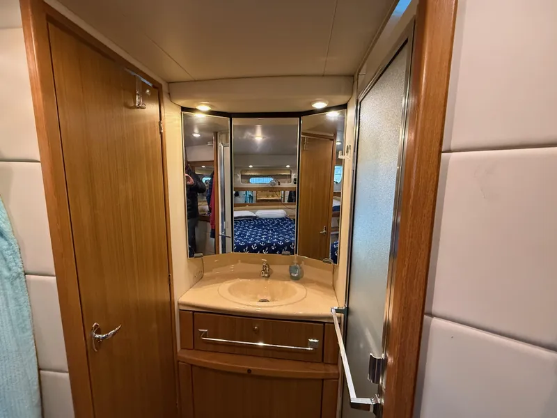 Slide: The Image of 2002 Bayliner 4087 Aft Cabin Motoryacht bathroom with wood cabinetry and mirrored vanity. - 19