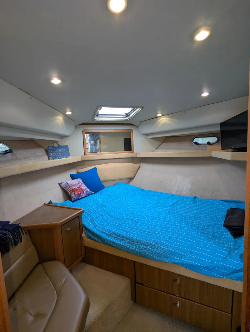 Slide: The Image of 2002 Bayliner 4087 Aft Cabin Motoryacht bedroom with blue bedding and cozy lighting. - 25