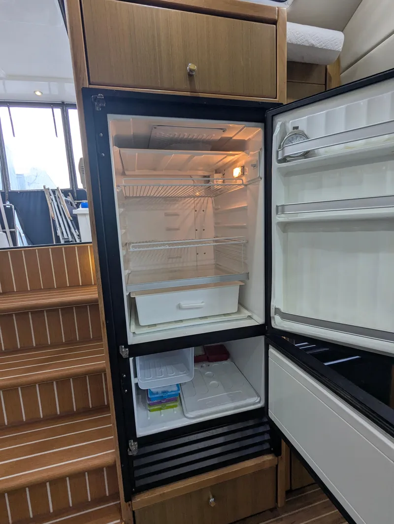 Slide: The Image of Open refrigerator inside 2002 Bayliner 4087 Aft Cabin Motoryacht, showcasing interior storage space. - 26