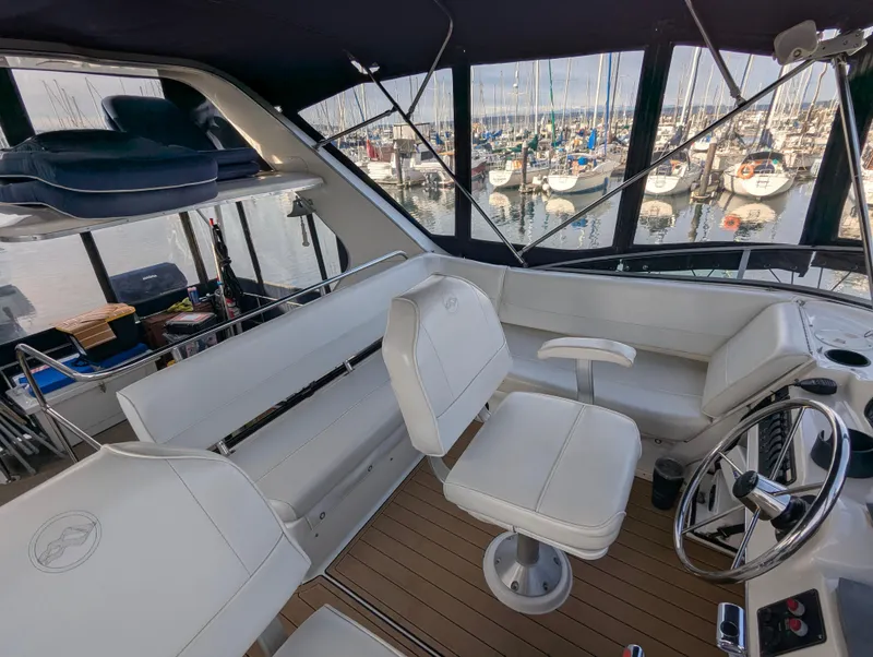 Slide: The Image of Bayliner 4087 Aft Cabin Motoryacht 2002 interior with helm, seating, and marina view. - 35