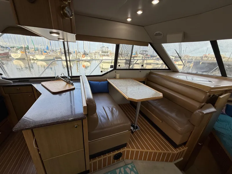 Slide: The Image of Interior of 2002 Bayliner 4087 Aft Cabin Motoryacht with dining area and marina view. - 6