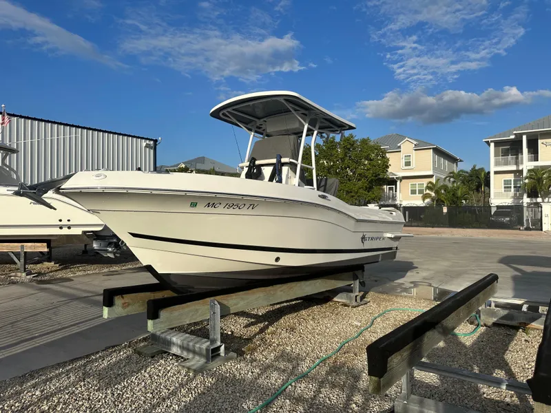 Slide: The Image of 2015 Striper 200 Center Console boat on a trailer, parked outdoors under a clear sky. - 1