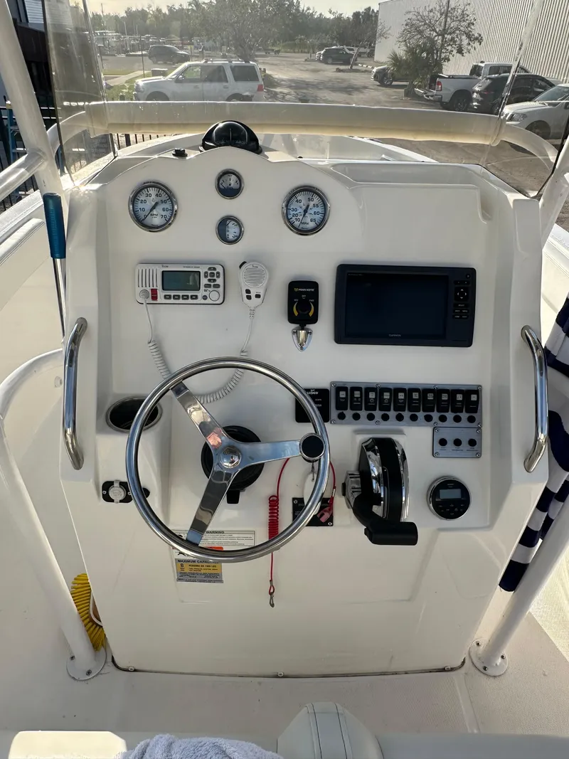 Slide: The Image of 2015 Striper 200 Center Console boat dashboard with steering wheel and navigation instruments. - 10