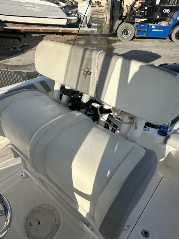 Slide: The Image of 2015 Striper 200 Center Console boat with cushioned seating in a marina setting. - 11