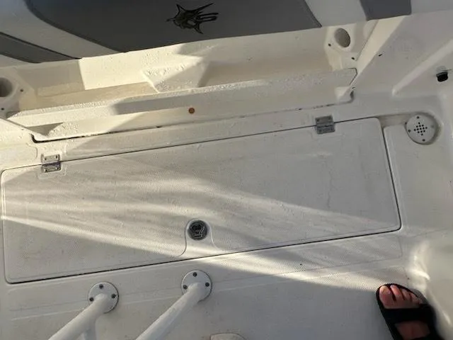 Slide: The Image of 2015 Striper 200 Center Console boat deck with storage compartment and rod holders. - 14