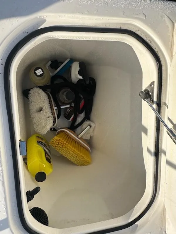 Slide: The Image of Storage compartment on a 2015 Striper 200 Center Console with cleaning supplies and brushes. - 15