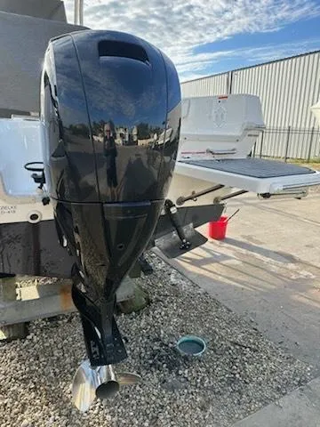 Slide: The Image of 2015 Striper 200 Center Console boat with a black outboard motor, parked outdoors. - 19