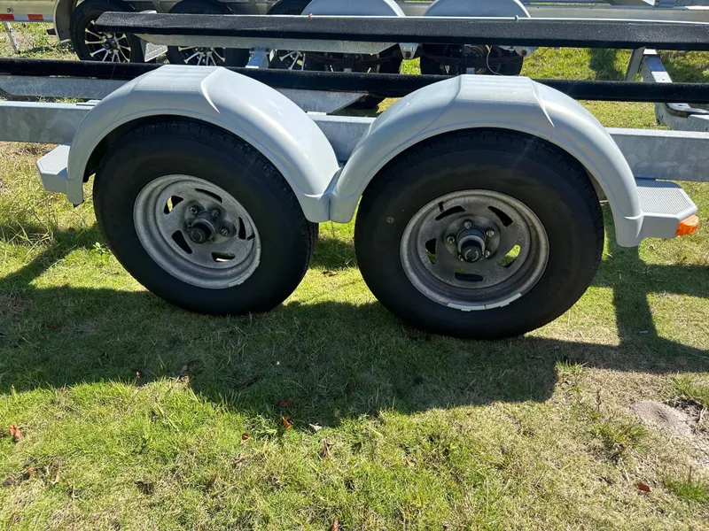 Slide: The Image of Trailer wheels for 2015 Striper 200 Center Console on grassy ground. - 21