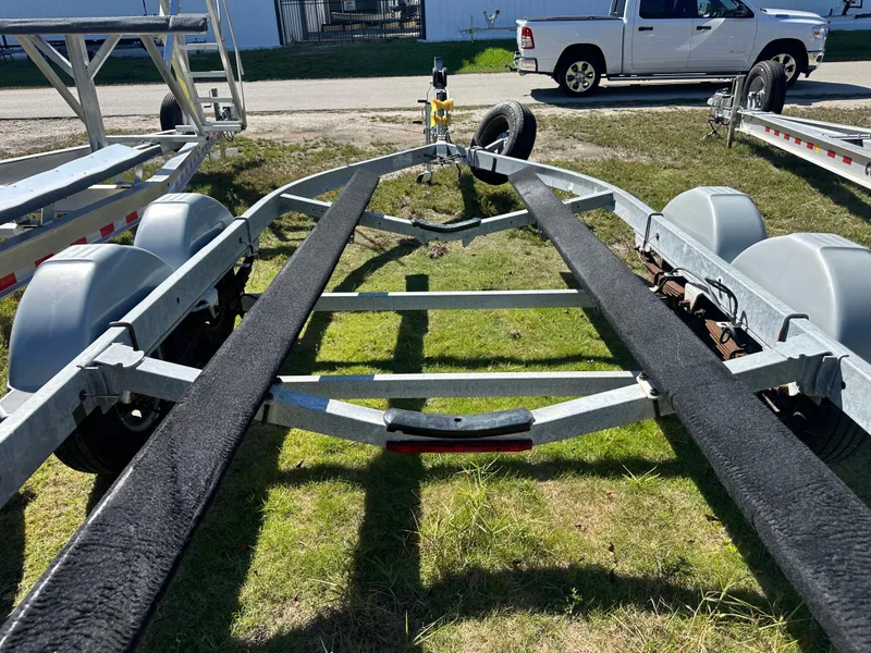 Slide: The Image of Boat trailer for 2015 Striper 200 Center Console on grass, with parked truck nearby. - 22